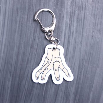 Thing Bag Tag. This bag tag is made with acrylic and heat pressed. Comes with lobster clasp topper that easily hooks to a bag, zippers, and lanyards for fun display and swivels. White backside.