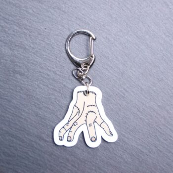 Thing Bag Tag. This bag tag is made with acrylic and heat pressed. Comes with lobster clasp topper that easily hooks to a bag, zippers, and lanyards for fun display and swivels. White backside.