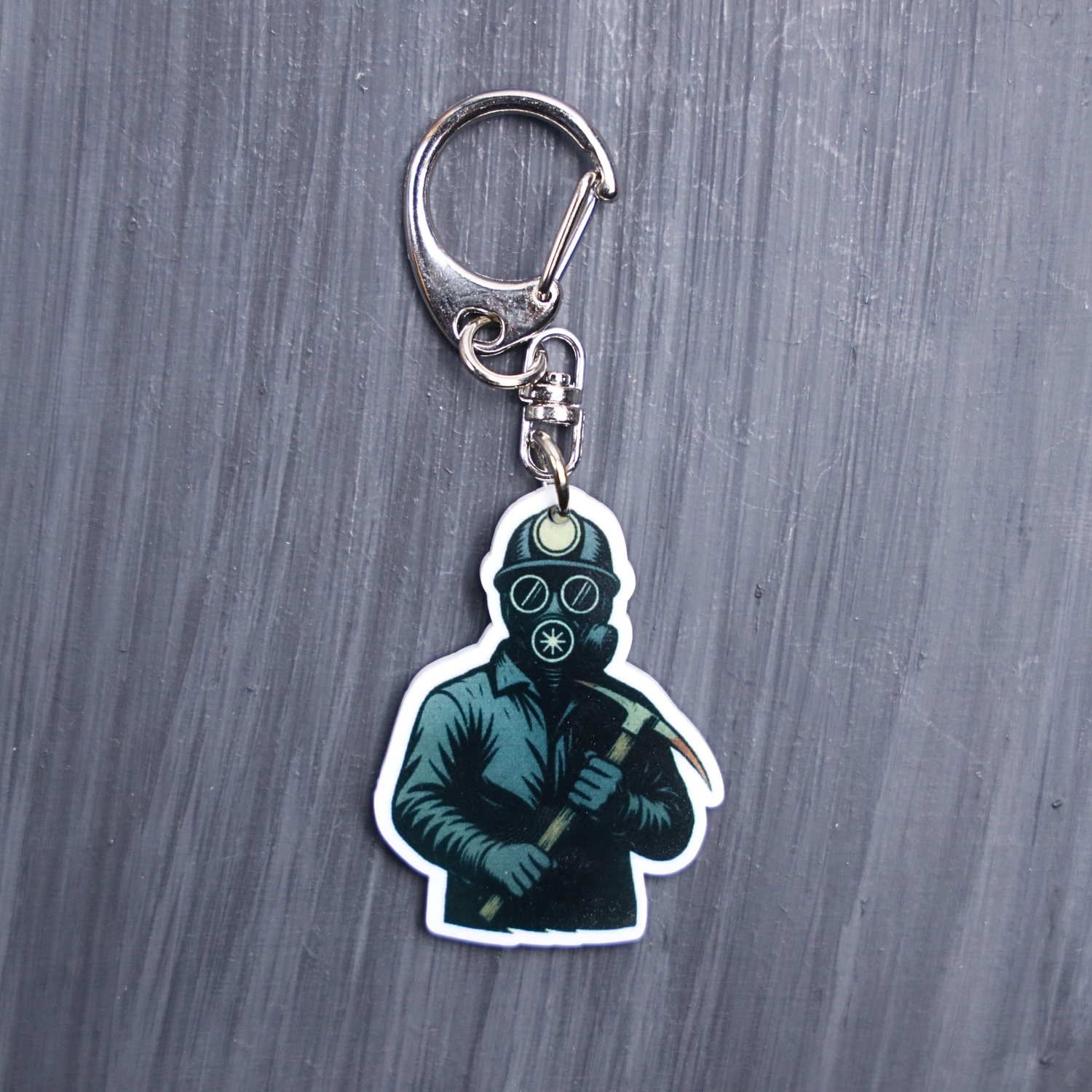 Bloody Miner Bag Tag. This bag tag is made with acrylic and heat pressed. Comes with lobster clasp topper that easily hooks to a bag, zippers, and lanyards for fun display and swivels. White backside.