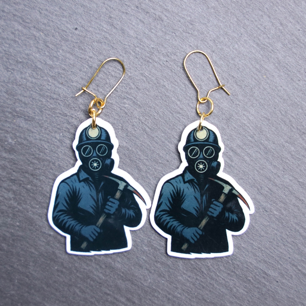 Bloody Miner Earrings. These earrings are made with acrylic and hand heat pressed. Comes with 18k plated gold hooks that is nickel free. Easily put loop through ear and hook back so the earring doesn’t fall out.