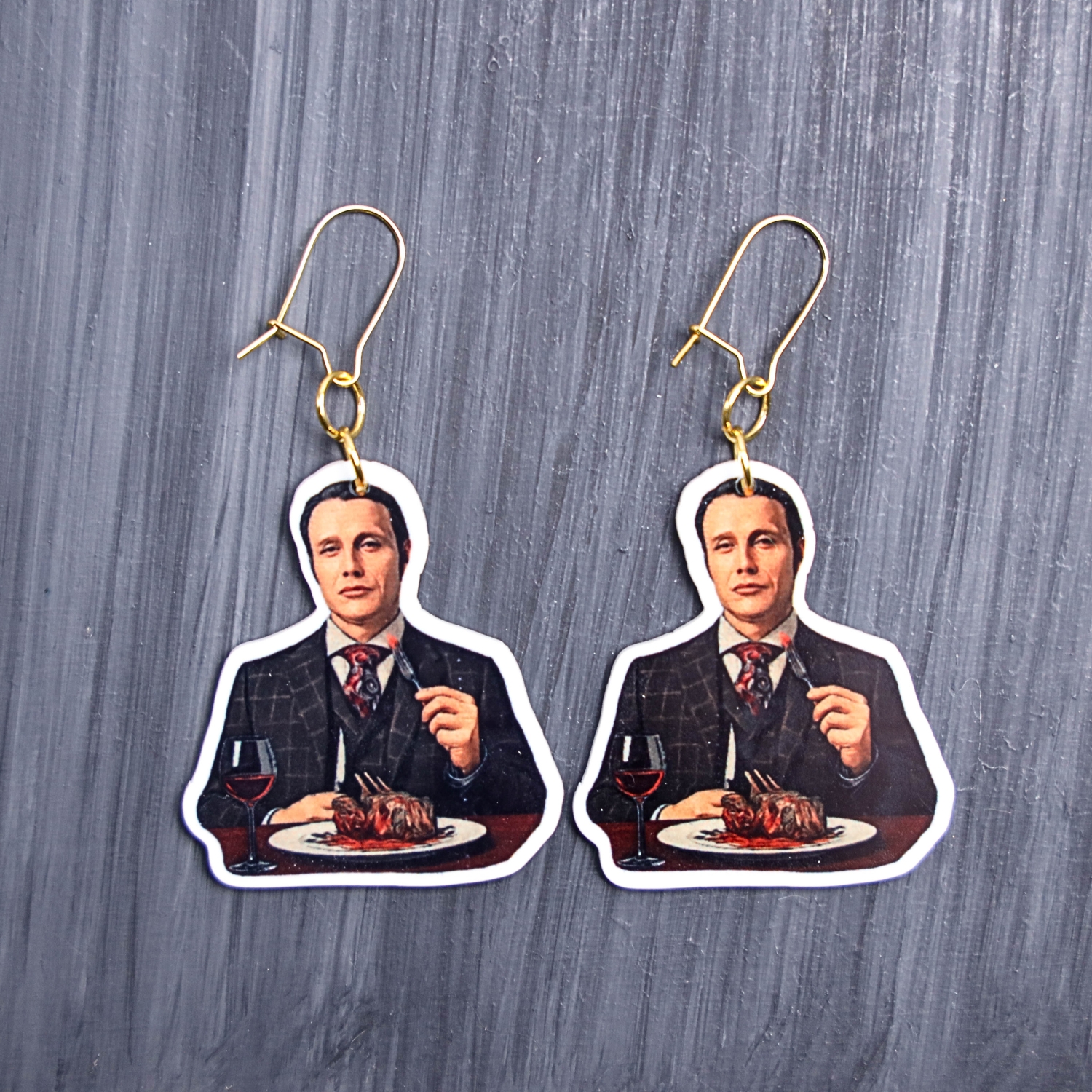 Chesapeake Ripper Eats Earrings. These earrings are made with acrylic and hand heat pressed. Comes with 18k plated gold hooks that is nickel free. Easily put loop through ear and hook back so the earring doesn’t fall out.