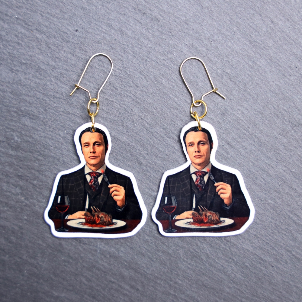 Chesapeake Ripper Eats Earrings. These earrings are made with acrylic and hand heat pressed. Comes with 18k plated gold hooks that is nickel free. Easily put loop through ear and hook back so the earring doesn’t fall out.