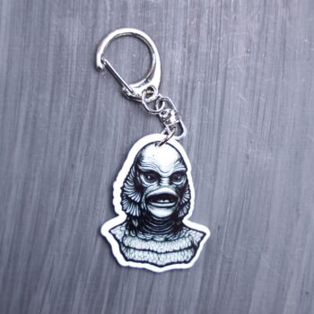 Creature Bag Tag. This bag tag is made with acrylic and heat pressed. Comes with lobster clasp topper that easily hooks to a bag, zippers, and lanyards for fun display and swivels. White backside.