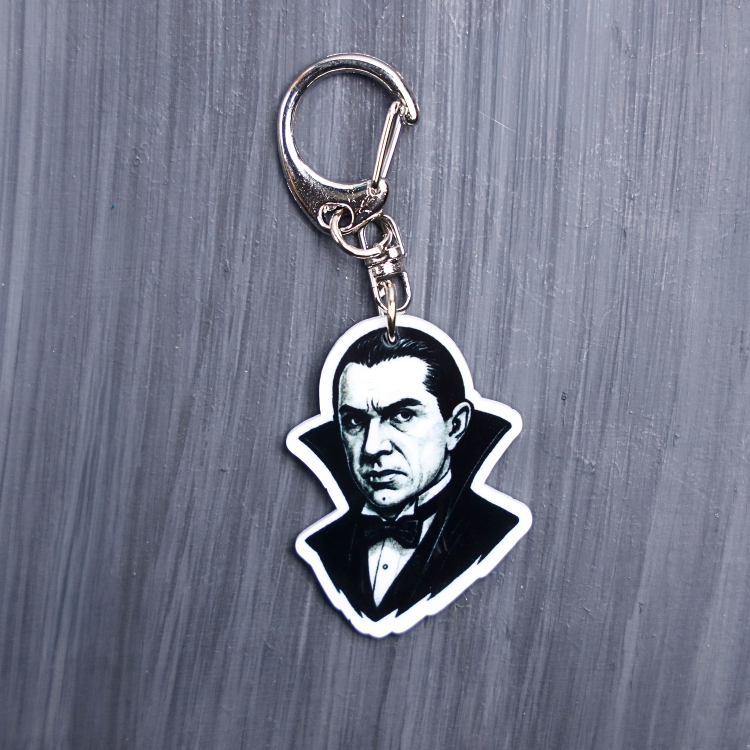 Dracula Bag Tag. This bag tag is made with acrylic and heat pressed. Comes with lobster clasp topper that easily hooks to a bag, zippers, and lanyards for fun display and swivels. White backside.
