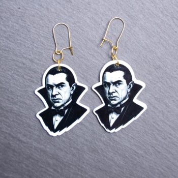 Dracula Earrings. These earrings are made with acrylic and hand heat pressed. Comes with 18k plated gold hooks that is nickel free. Easily put loop through ear and hook back so the earring doesn’t fall out.