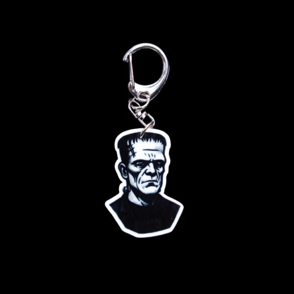 Frank Bag Tag. This bag tag is made with acrylic and heat pressed. Comes with lobster clasp topper that easily hooks to a bag, zippers, and lanyards for fun display and swivels. White backside.