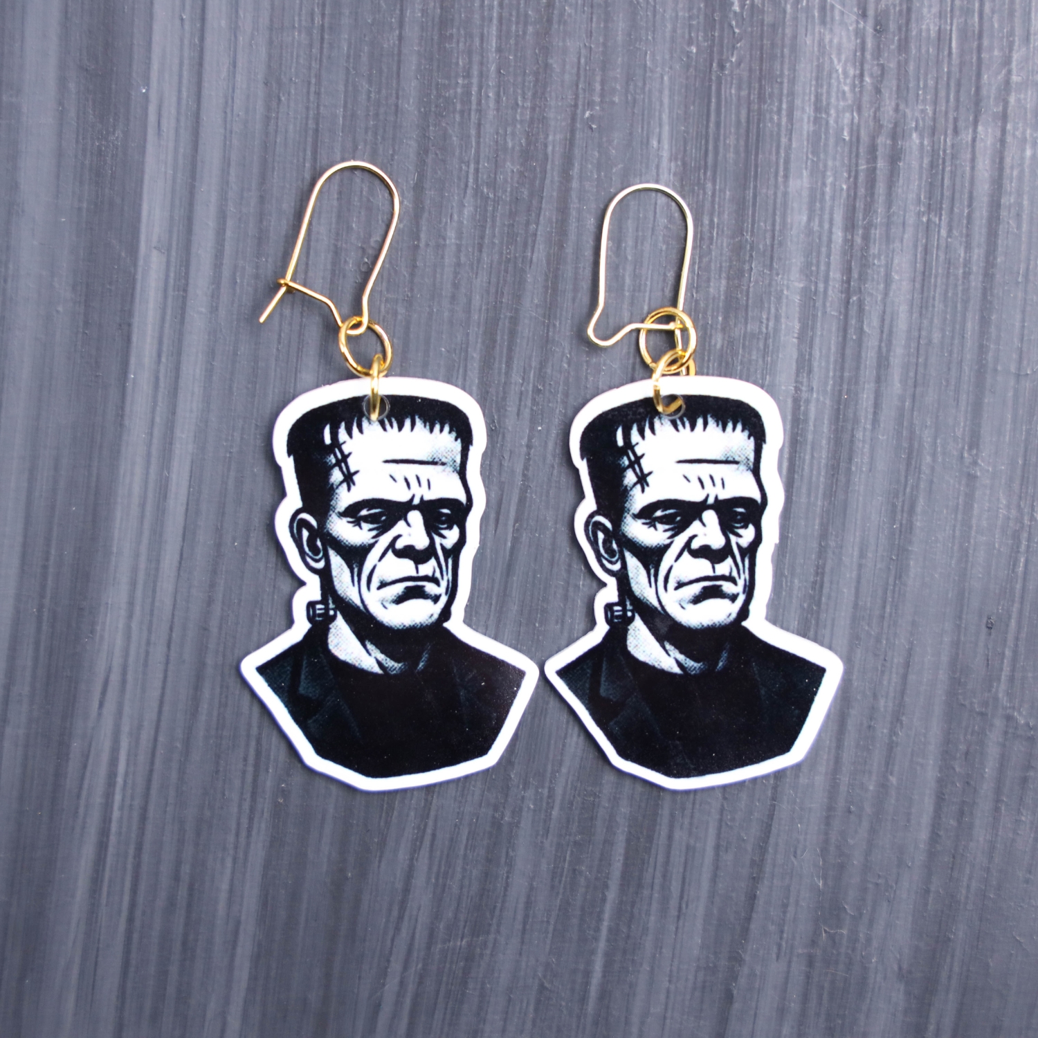 Frank Earrings. These earrings are made with acrylic and hand heat pressed. Comes with 18k plated gold hooks that is nickel free. Easily put loop through ear and hook back so the earring doesn’t fall out.