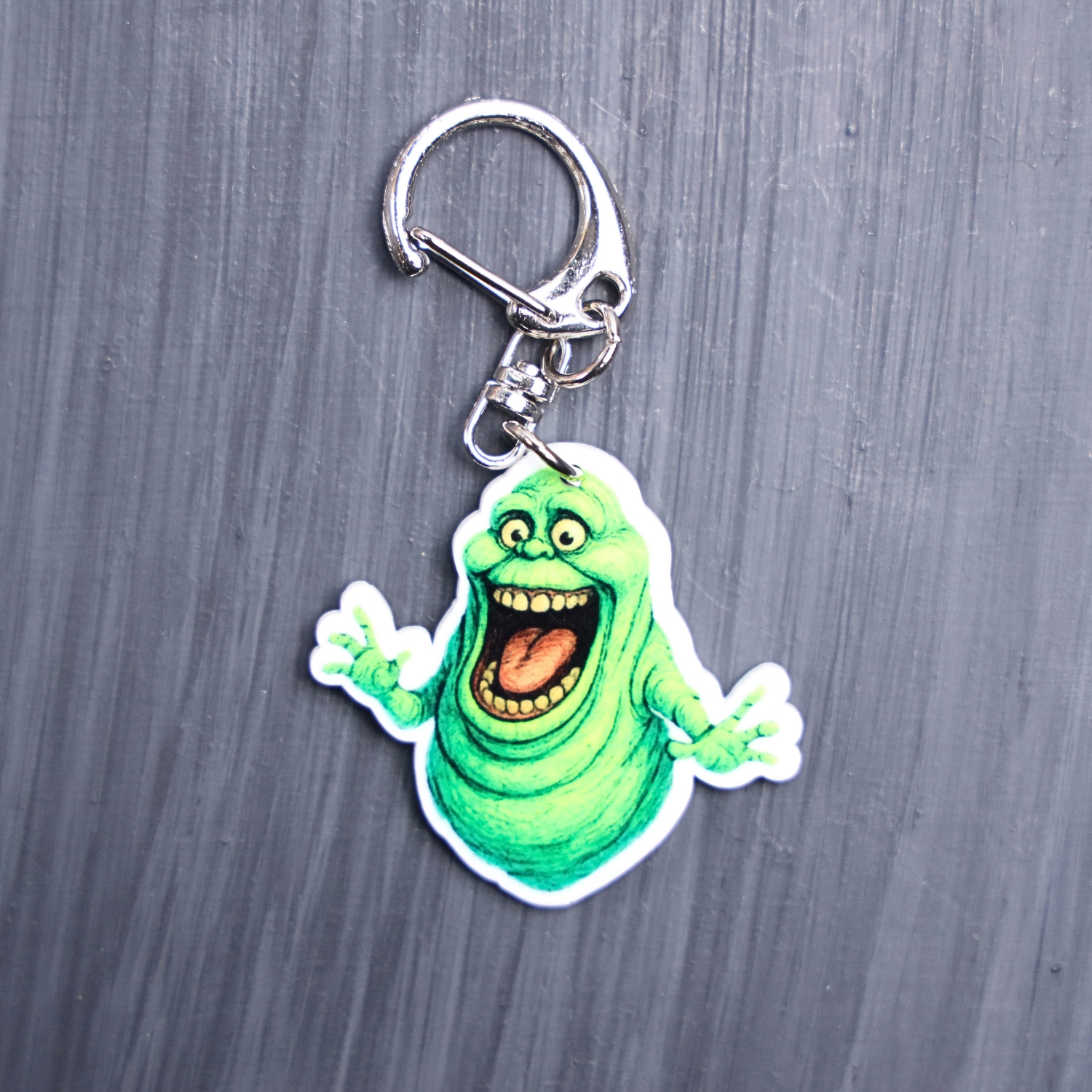 Green Ghost Bag Tag. This bag tag is made with acrylic and heat pressed. Comes with lobster clasp topper that easily hooks to a bag, zippers, and lanyards for fun display and swivels. White backside.