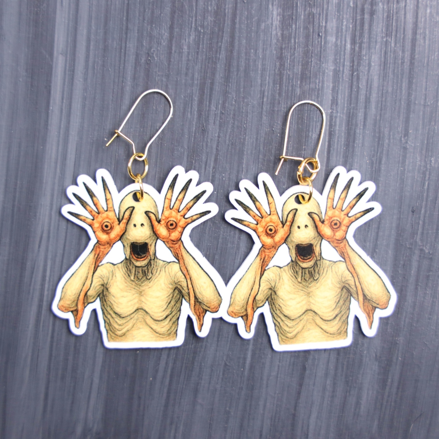 Pale One Earrings. These earrings are made with acrylic and hand heat pressed. Comes with 18k plated gold hooks that is nickel free. Easily put loop through ear and hook back so the earring doesn’t fall out.