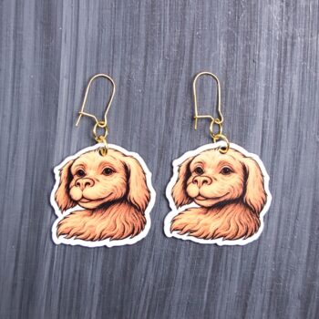 White Dragon Dog Earrings. These earrings are made with acrylic and hand heat pressed. Comes with 18k plated gold hooks that is nickel free. Easily put loop through ear and hook back so the earring doesn’t fall out.