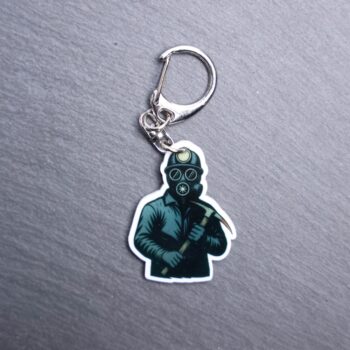 Bloody Miner Bag Tag. This bag tag is made with acrylic and heat pressed. Comes with lobster clasp topper that easily hooks to a bag, zippers, and lanyards for fun display and swivels. White backside.