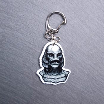 Creature Bag Tag. This bag tag is made with acrylic and heat pressed. Comes with lobster clasp topper that easily hooks to a bag, zippers, and lanyards for fun display and swivels. White backside.