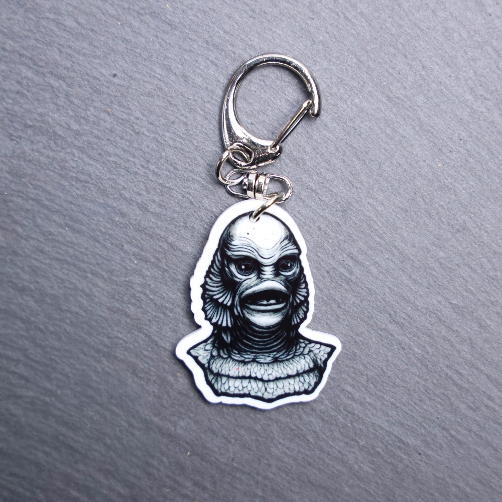 Creature Bag Tag. This bag tag is made with acrylic and heat pressed. Comes with lobster clasp topper that easily hooks to a bag, zippers, and lanyards for fun display and swivels. White backside.