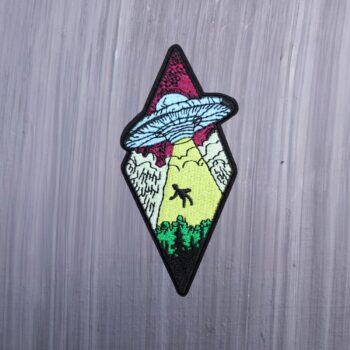 Alien abduction patch with spaceship, light beam, and trees. Beautifully embroidered design with an adhesive for easy application to your favorite bag or article of clothing.