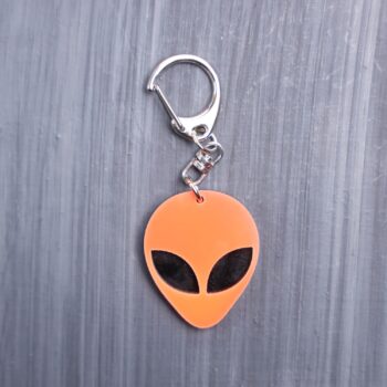 Alien Head Neon Orange Bag Tag with black eyes and black backing. Acrylic designed charm with a swivel lobster snap hook in high quality metal alloy.