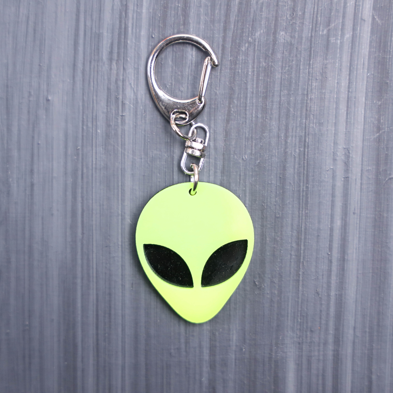 Alien Head Neon Yellow Bag Tag with black eyes and black backing. Acrylic designed charm with a swivel lobster snap hook in high quality metal alloy.