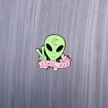 Alien Stay Rad Enamel Pin green alien with pink and moon on his head. These enamel pins are made with metal. These enamel pins are colorful, with a black backing.
