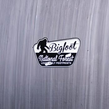 Bigfoot National Forest Leave Only Footprints Enamel Pin in black and white. These enamel pins are made with metal. These enamel pins are colorful, with a black backing.