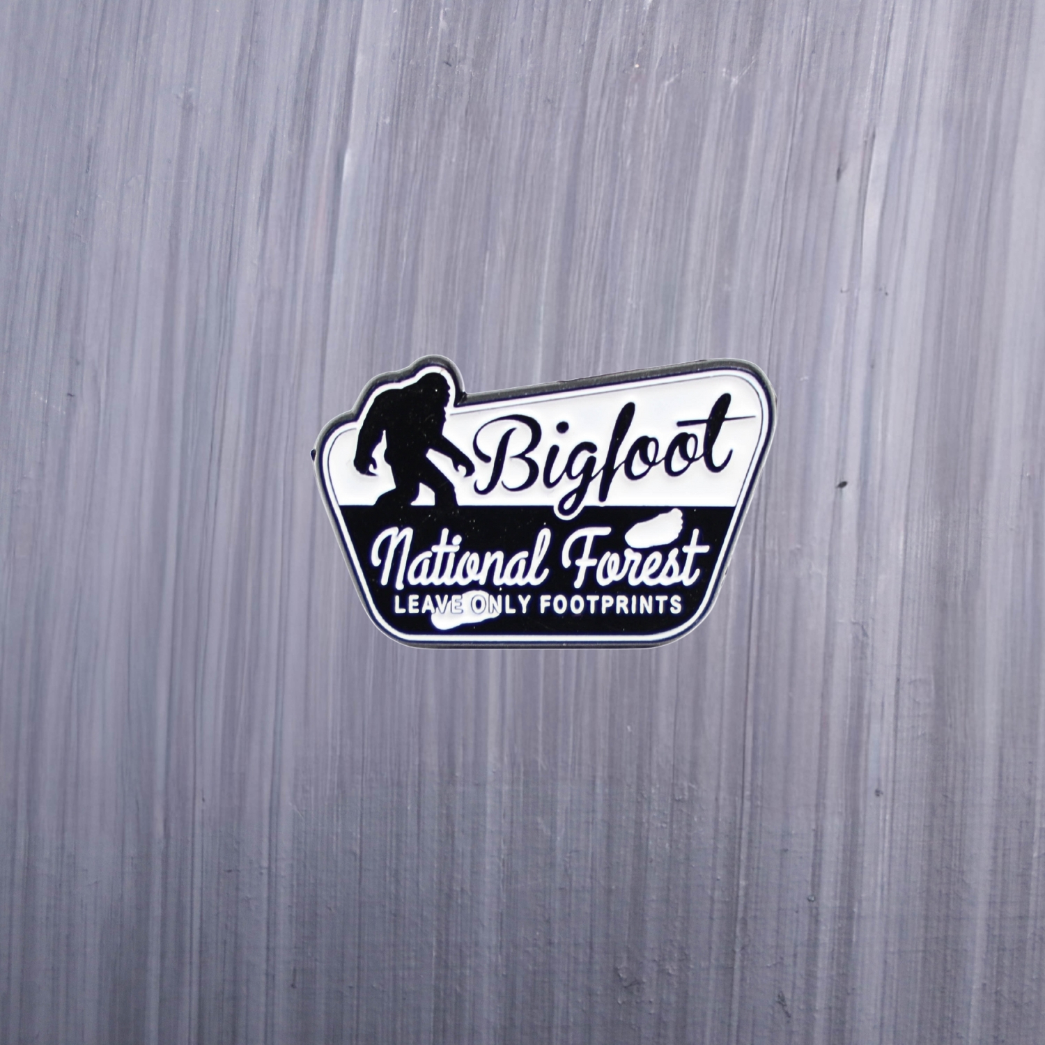 Bigfoot National Forest Leave Only Footprints Enamel Pin in black and white. These enamel pins are made with metal. These enamel pins are colorful, with a black backing.