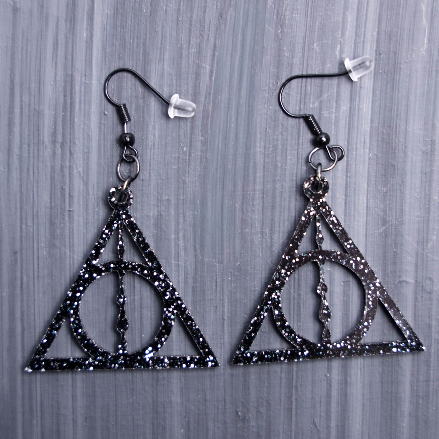 Deathly Hallows Earrings. These earrings are made with glitter black acrylic. Comes with black hooks that is nickel free.