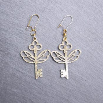 Flying Keys Earrings. These earrings are made with gold glitter acrylic. Comes with gold hooks that is nickel free.