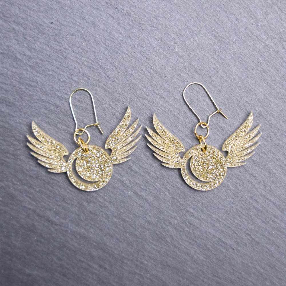 Golden Snitch Glitter Earrings. These earrings are made with gold glitter acrylic. Comes with gold hooks that is nickel free.