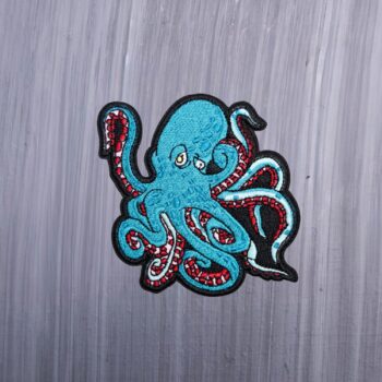 Kraken Patch in a turquoise blue and maroon. Beautifully embroidered design with an adhesive for easy application to your favorite bag or article of clothing.