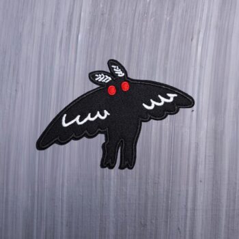 Mothman Flight Patch in black and white with red eyes. Beautifully embroidered design with an adhesive for easy application to your favorite bag or article of clothing.