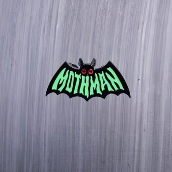 Mothman Green Enamel Pin says mothman on the front in green. Features red gel eyes. These enamel pins are made with metal. These enamel pins are colorful, with a black backing.