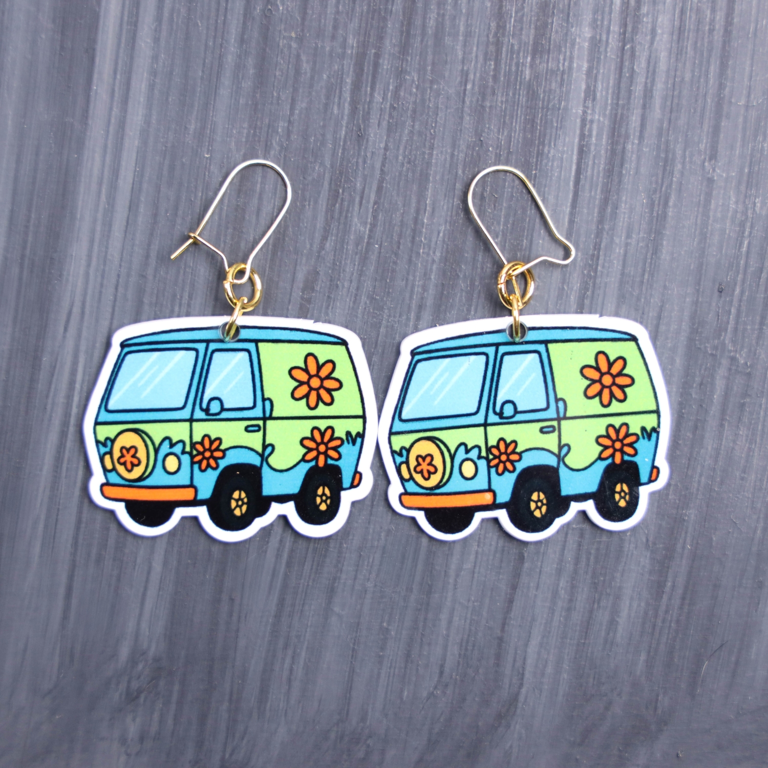 Mystery Van Earrings. These earrings are made with acrylic and hand heat pressed. Comes with 18k plated gold hooks that is nickel free. Easily put loop through ear and hook back so the earring doesn’t fall out.