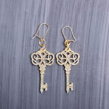Skeleton Key Earrings. These earrings are made with gold glitter acrylic. Comes with gold hooks that is nickel free.