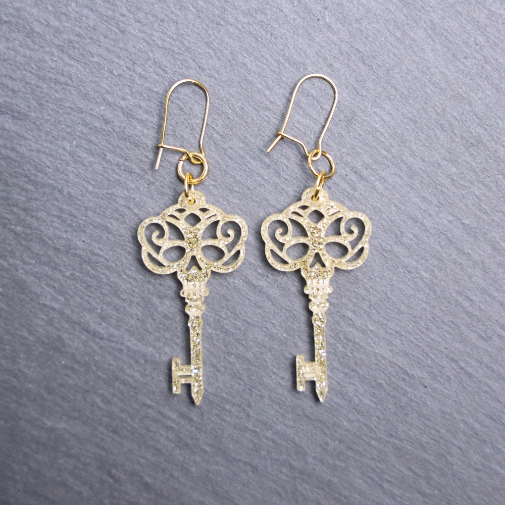 Skeleton Key Earrings. These earrings are made with gold glitter acrylic. Comes with gold hooks that is nickel free.