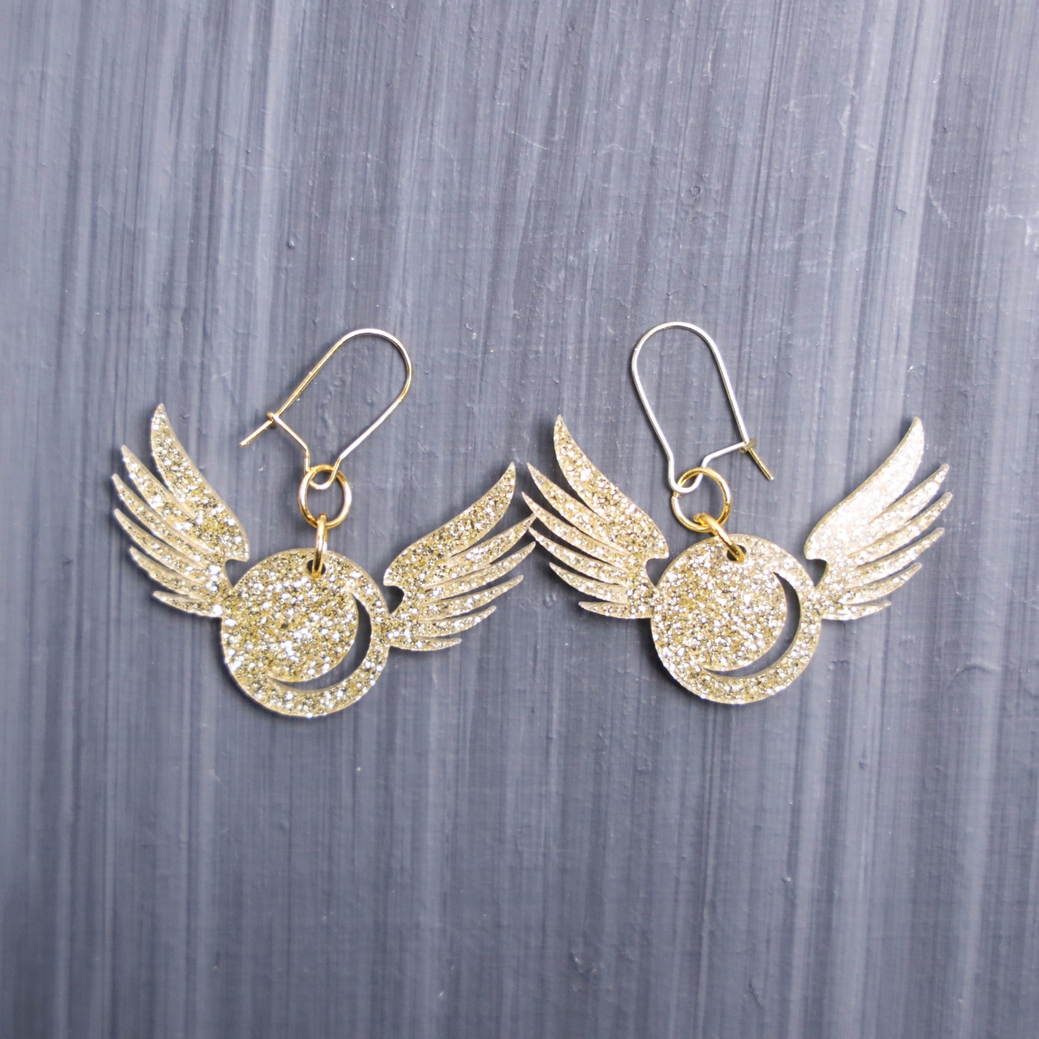 Golden Snitch Glitter Earrings. These earrings are made with gold glitter acrylic. Comes with gold hooks that is nickel free.