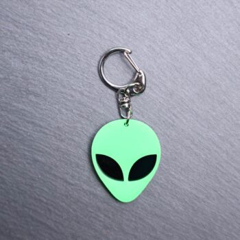 Alien Head Neon Green Bag Tag with black eyes and black backing. Acrylic designed charm with a swivel lobster snap hook in high quality metal alloy.