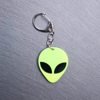 Alien Head Neon Yellow Bag Tag with black eyes and black backing. Acrylic designed charm with a swivel lobster snap hook in high quality metal alloy.