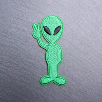Alien Peace Sign Patch in green holding up the peace sign. Beautifully embroidered design with an adhesive for easy application to your favorite bag or article of clothing.