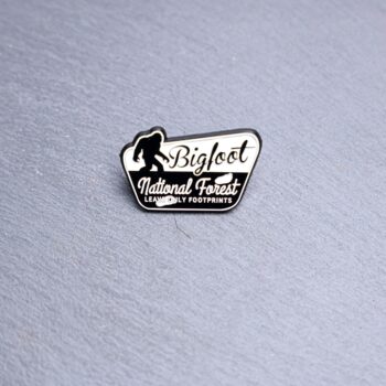 Bigfoot National Forest Leave Only Footprints Enamel Pin in black and white. These enamel pins are made with metal. These enamel pins are colorful, with a black backing.