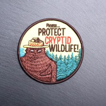 Protect Cryptid Wildlife patch with frog with sasquatch in a hat. Beautifully embroidered design with an adhesive for easy application to your favorite bag or article of clothing.