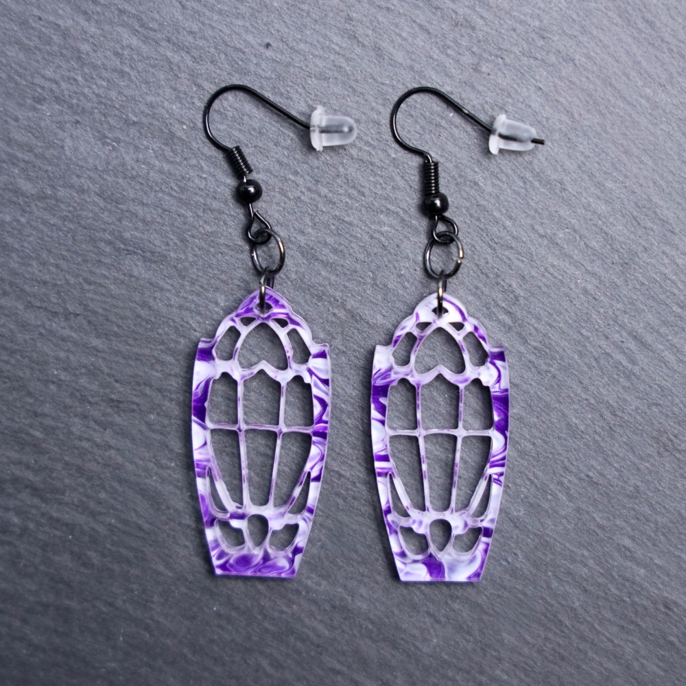 Dracula’s Window Purple Earrings. These earrings are made with white and purple acrylic. Comes with black hooks that is nickel free.