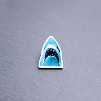 Jaws Acrylic Pin. These acrylic pins are made with cast acrylic. These pins are colorful, with a black pin back.