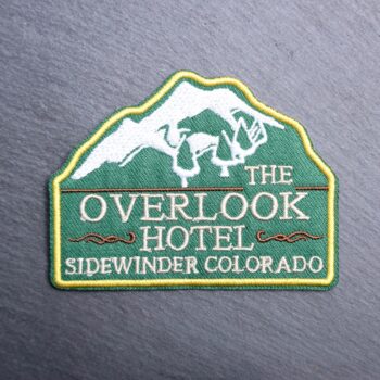 Overlook Hotel Patch with mountains and trees. Beautifully embroidered design with an adhesive for easy application to your favorite bag or article of clothing.