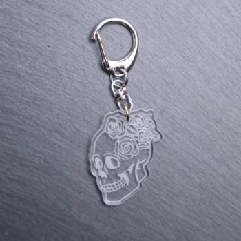 Floral Skull Bag Tag. This bag tag is made with engraved acrylic. Comes with lobster clasp topper that easily hooks to a bag, zippers, and lanyards for fun display and swivels.