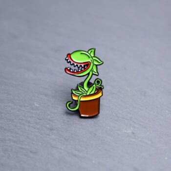 Audrey Enamel Pin which is a killer plant. These enamel pins are made with metal. These enamel pins are colorful, with a black backing.
