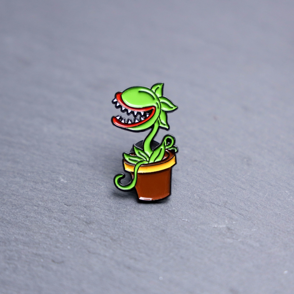 Audrey Enamel Pin which is a killer plant. These enamel pins are made with metal. These enamel pins are colorful, with a black backing.