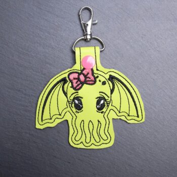 Cthulhu Snap Bag Tag. This bag tag is made with faux vinyl and embroidered. Comes with lobster clasp topper that easily hooks to a bag, zippers