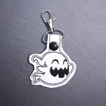 Happy Ghost Snap Bag Tag. This bag tag is made with faux vinyl and embroidered. Comes with lobster clasp topper that easily hooks to a bag, zippers