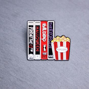 Horror Movie VHS Popcorn Enamel Pin with classic VHS horror movies. These enamel pins are made with metal. These enamel pins are colorful, with a black backing.