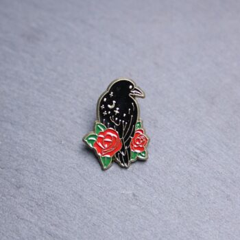 Raven Rose Enamel Pin with black raven and roses. These enamel pins are made with metal. These enamel pins are colorful, with a black backing.