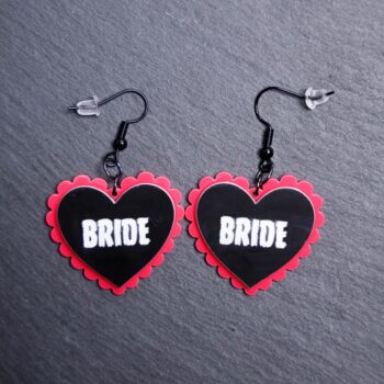 Bride Pillow Earrings that are white, black and pink. These earrings are made with engraved acrylic. Comes with black hooks that is nickel free.