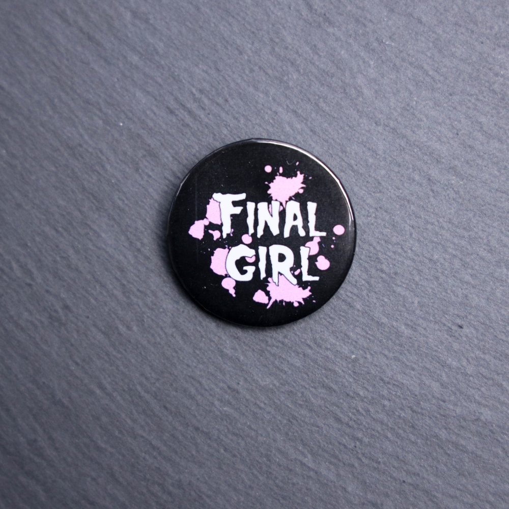Final Girl Pink Button. These buttons are made with photo paper, metal round, and metal backing. These buttons are vibrant and fun to use on bags or vests.